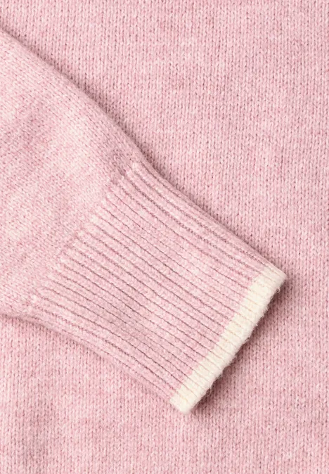Nahaufnahme eines rosa gestrickten Pullovers mit Rippbündchen.