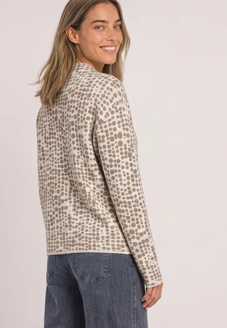 Pullover mit Turtle Neck und Jacquardmuster pure beige Eine Frau mit hellem, bedrucktem Langarmshirt dreht sich lächelnd um.