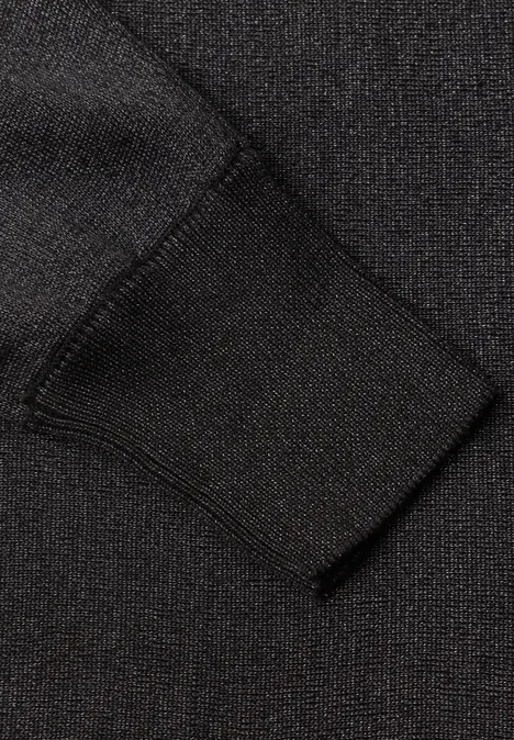 Dolman Pullover mit Glitzerdetails Black Schwarzer Pulloverärmel mit Rippstrickbündchen auf texturierter Stoffoberfläche.