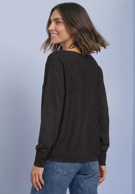 Dolman Pullover mit Glitzerdetails black coffee Frau im schwarzen Pullover und Jeans, sieht lächelnd zurück.