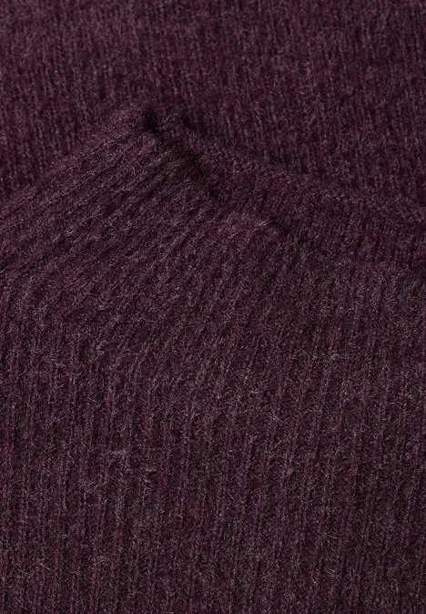 Federgarn Pullover mit Turtle Neck berry plum Nahaufnahme eines dunkelvioletten, gerippten Strickstoffs.