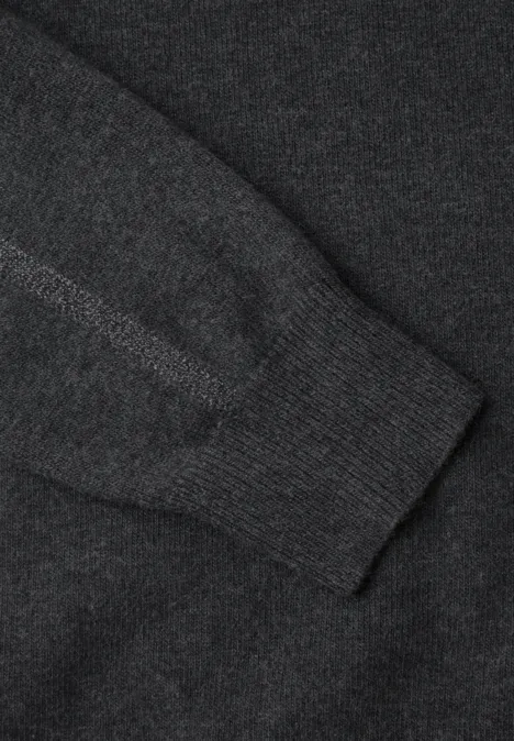 Gros plan d'un pull en maille gris foncé avec poignet côtelé.