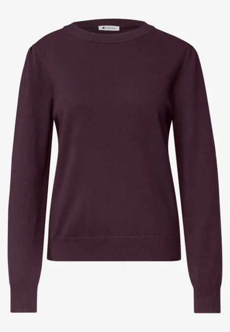 Un pull à manches longues bordeaux uni avec col rond.