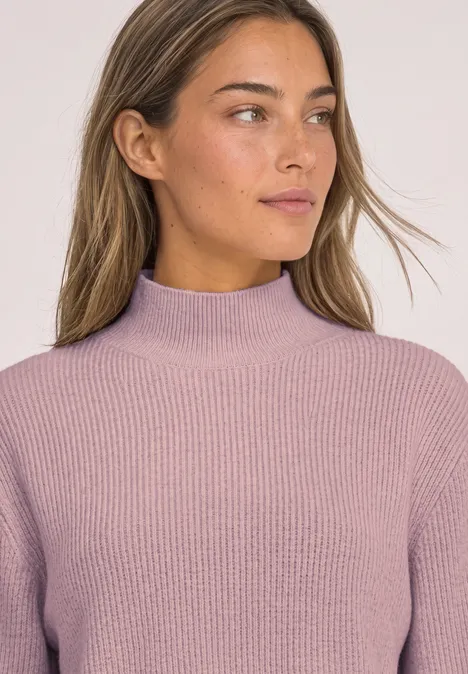 Pullover im Melange-Look mit Turtle Neck quiet rose mel. Frau mit schulterlangem braunem Haar, trägt einen fliederfarbenen Rollkragenpullover, schaut nach rechts.