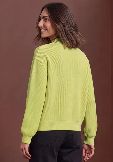 Pullover im Melange-Look mit Turtle Neck apple lime mel. Eine Frau in einem hellgrünen Pullover blickt über die Schulter.