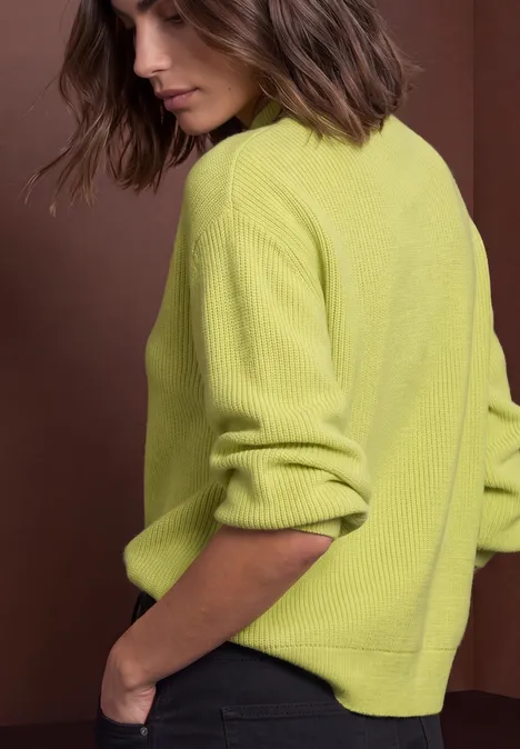 Pullover im Melange-Look mit Turtle Neck apple lime mel. Frau mit schulterlangem braunem Haar trägt einen hellgrünen, gerippten Pullover vor braunem Hintergrund.