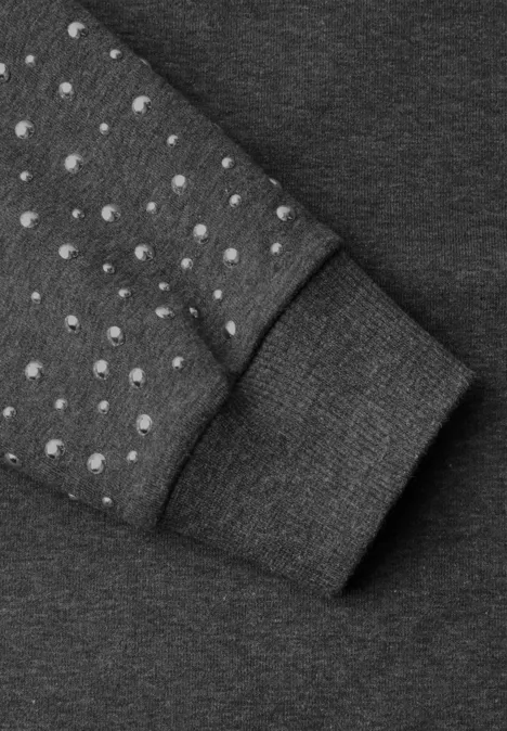 Loose Fit Sweatshirt mit Nieten armor grey mel. Nahaufnahme eines grauen Kleidungsstücks mit runden Noppen auf dem Ärmel und einem Bündchen.