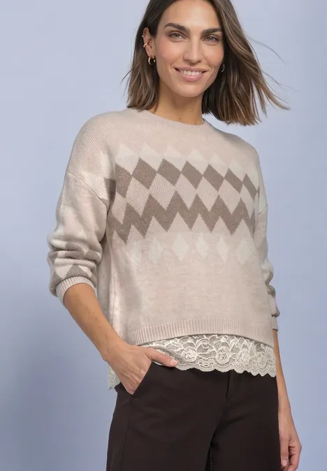 Pullover mit Jacquardmuster und Spitze clay sand mel. Frau in beigem Strickpullover mit Zickzackmuster und Spitzenbesatz, dunkelbraune Hose vor neutralem Hintergrund.
