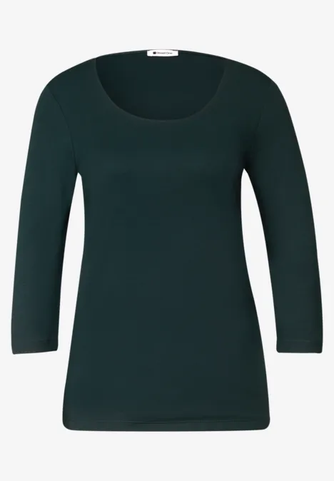 Dunkelgrünes Shirt mit U-Ausschnitt und 3/4-Ärmeln, schlicht geschnitten.