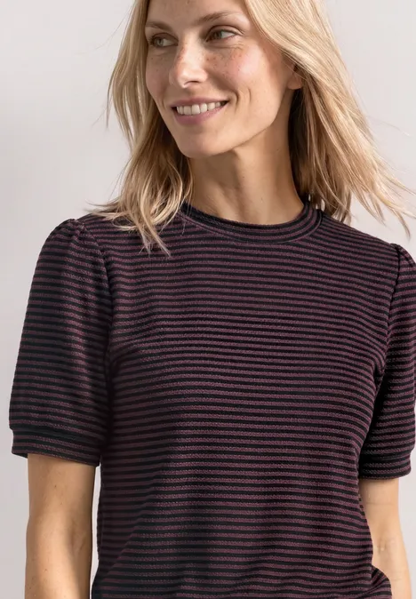Lächelnde Frau mit blonden Haaren in einem gestreiften Kurzarmshirt.