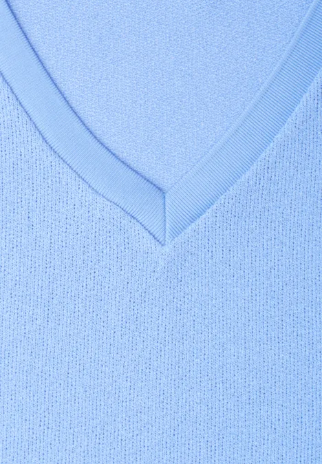 Nahaufnahme eines hellblauen V-Ausschnitts aus fein gestricktem Stoff.