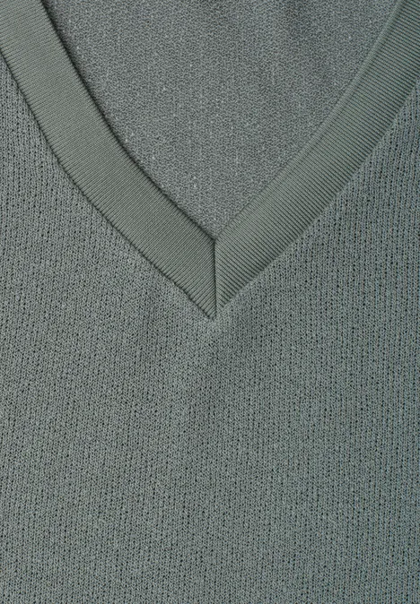 Nahaufnahme eines grauen V-Ausschnitts aus feinem Strickstoff mit dezenter Struktur.