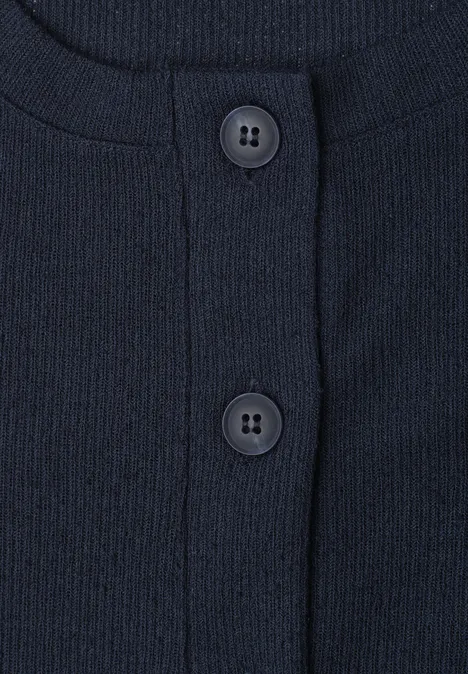Nahaufnahme eines dunkelblauen, gerippten Oberteils mit Rundhalsausschnitt und zwei Knöpfen.