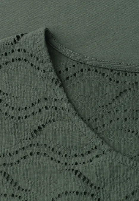 Dunkelgrünes Textil mit wellenförmigem Lochmuster und Rundhalsausschnitt.