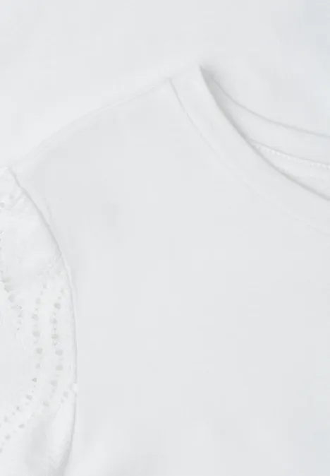 Naheinstellung eines weißen Kinder-T-Shirts mit zarten Spitzenärmeln.