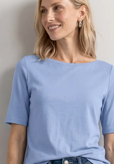 Basic T-Shirt mit U-Boot-Ausschnitt northern blue Eine lächelnde Frau mit schulterlangem blonden Haar trägt ein hellblaues T-Shirt mit kurzen Ärmeln.