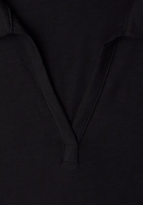 Schwarzes Stoffdetail mit V-förmigem Ausschnitt, vermutlich Teil eines T-Shirts oder Poloshirts.