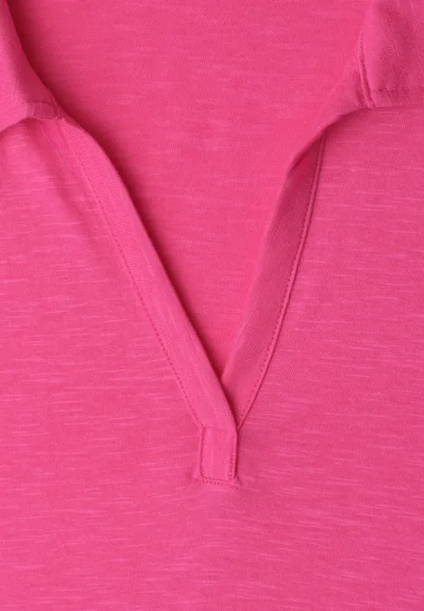 Close-up van een roze fuchsia T-shirt met kraag en V-hals