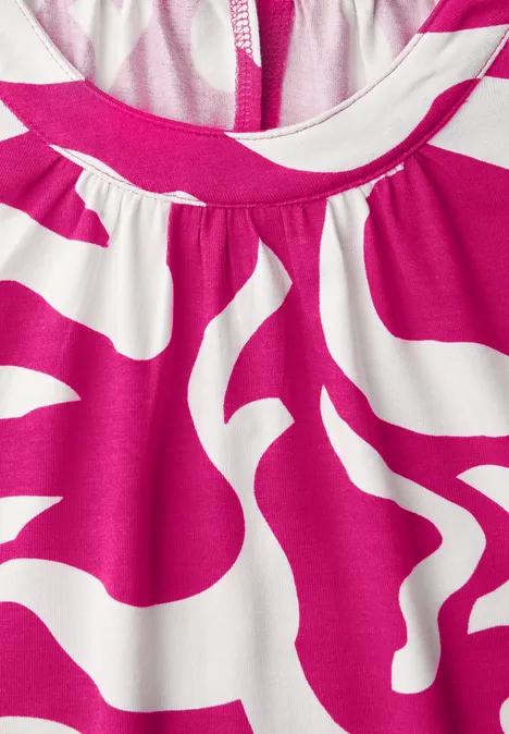 Close-up van een roze-wit top met abstract patroon en ronde halslijn