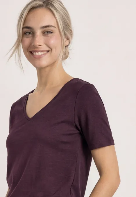 Basic T-Shirt mit Herzausschnitt rustic rouge Frau mit hellblonden Haaren lächelt in violettem V-Ausschnitt-T-Shirt vor weißem Hintergrund.