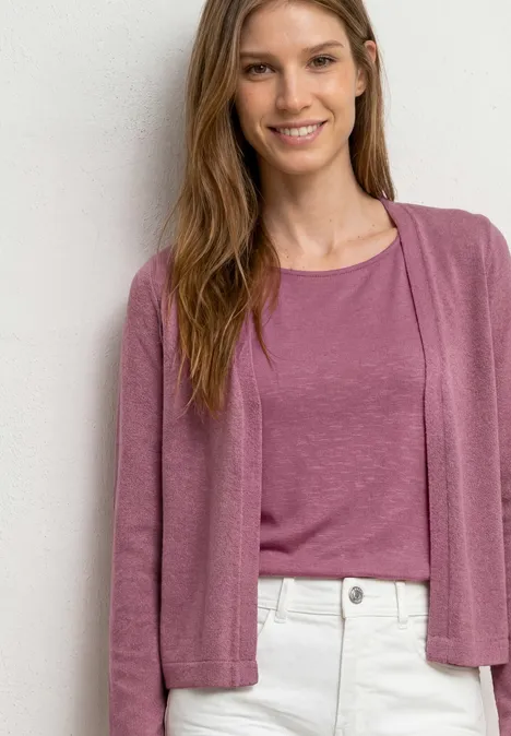 Veste à manches longues en look tricot dark clouded blush Femme portant un t-shirt et un gilet roses, pantalon clair, devant un mur blanc.