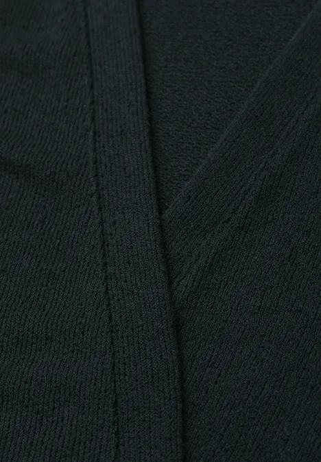 Nahaufnahme eines schwarzen Strickstoffs mit markanter Naht.