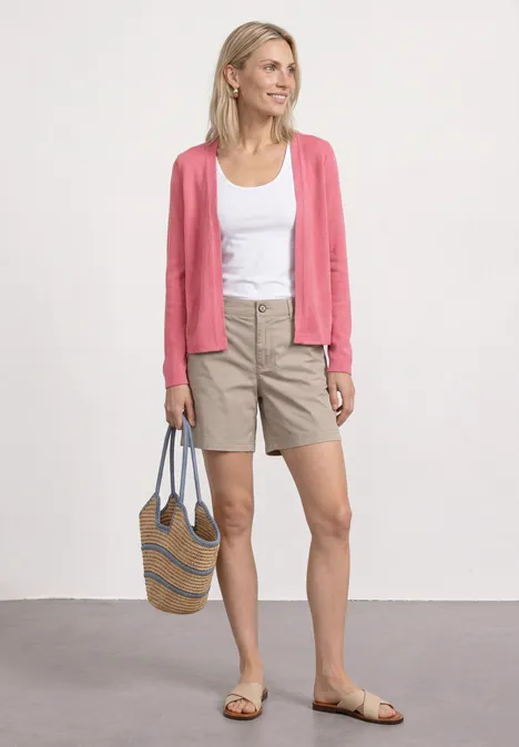 Veste à manches longues en look tricot blush berry Femme en débardeur blanc, cardigan rose, short beige et sandales, tenant un sac.