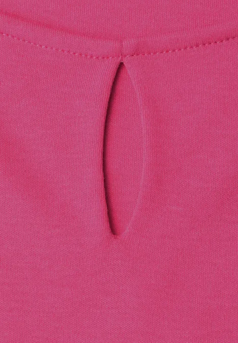 Close-up van felroze stof met kleine druppelvormige halsuitsnijding