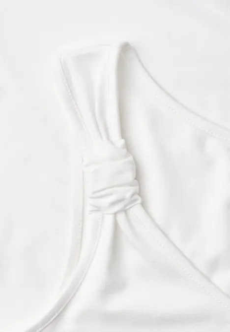 Witte mouwloze top met gedraaide schouderbandknoop, minimalistisch design.