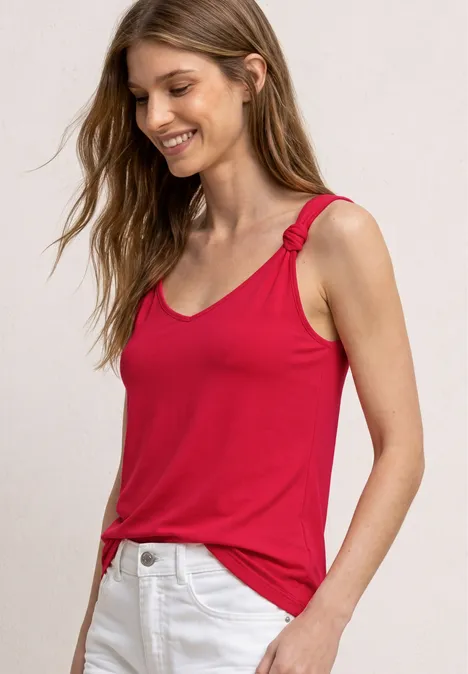Top mit V-Neck und Knotendetail salsa red Frau im roten, ärmellosen Top mit Schulterknoten und weißer Hose.