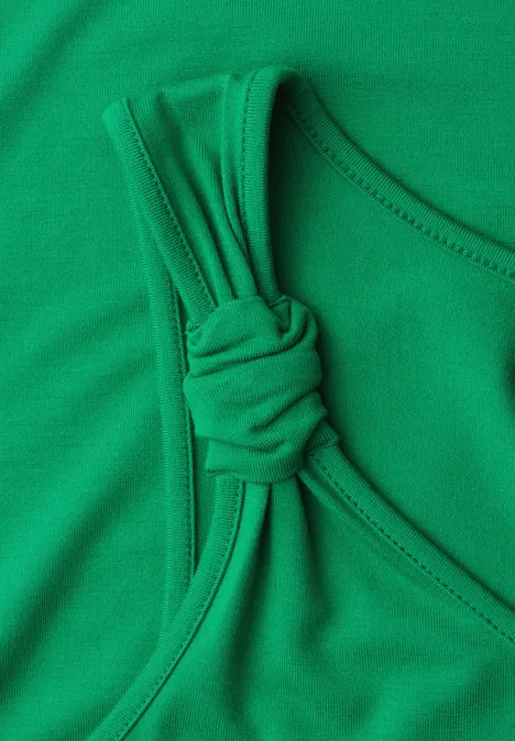 Groen mouwloos badpaktopje met decoratieve knoop op de schouderband.