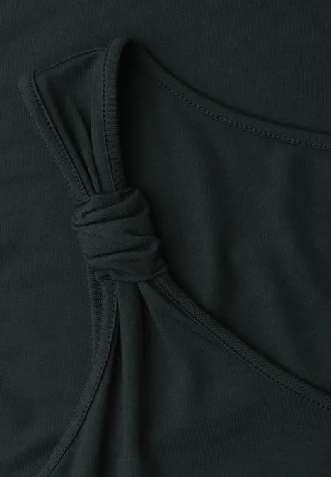 Close-up van een zwart topje met knoopdetail aan het bandje