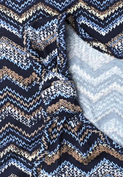 Nahaufnahme eines Textils mit blau-schwarz-beigen Chevron-Streifen