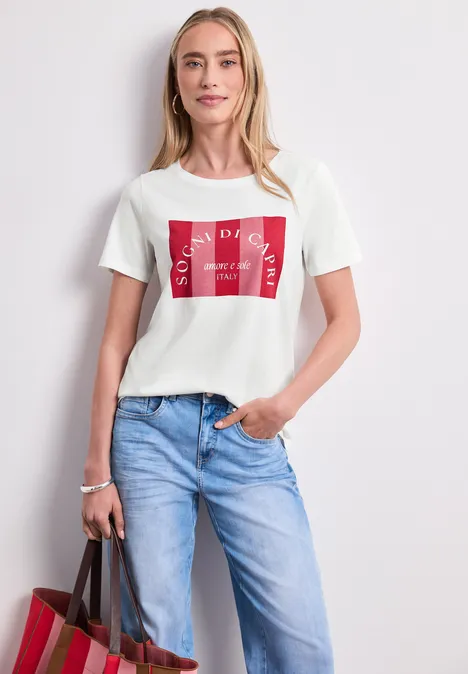 T-Shirt mit Rundhals und Print off white Eine Frau in blauer Jeans und weißem T-Shirt mit rotem Print, die eine Tasche trägt.