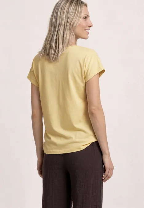 Koszulka na ramiączkach z okrągłym dekoltem soft yellow Widok z tyłu: blondynka w żółtej koszulce i brązowych spodniach na jasnym tle.