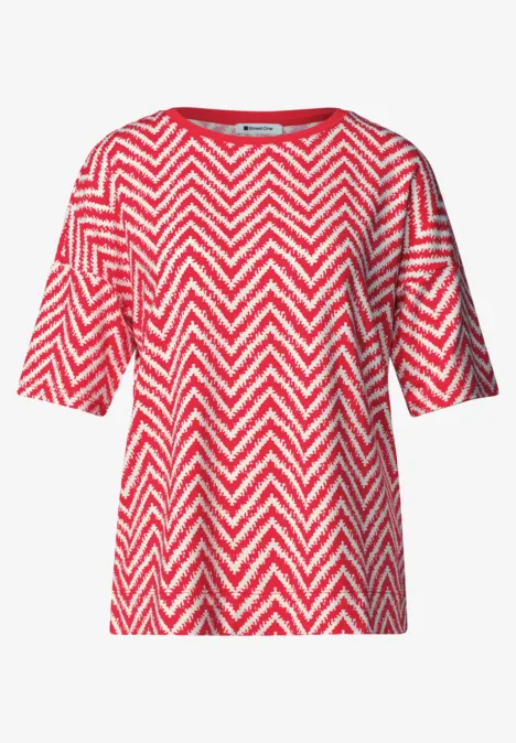 Rotes T-Shirt mit weißem Zickzackmuster und kurzen Ärmeln.