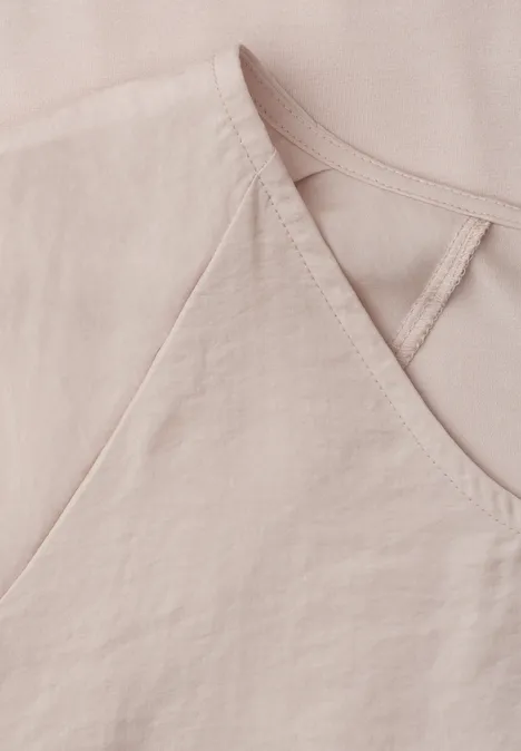 Close-up van een lichtroze linnen top met V-hals