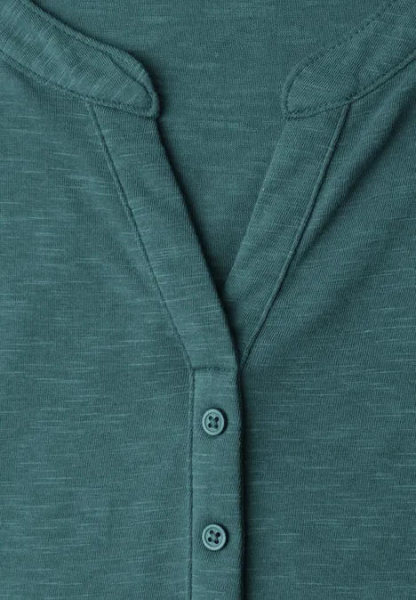 Dropped Shoulder Shirt mit Split Neck mediterra green Detailaufnahme eines tealfarbenen Langarm-Henleyshirts mit Knopfleiste und Ziernähten.