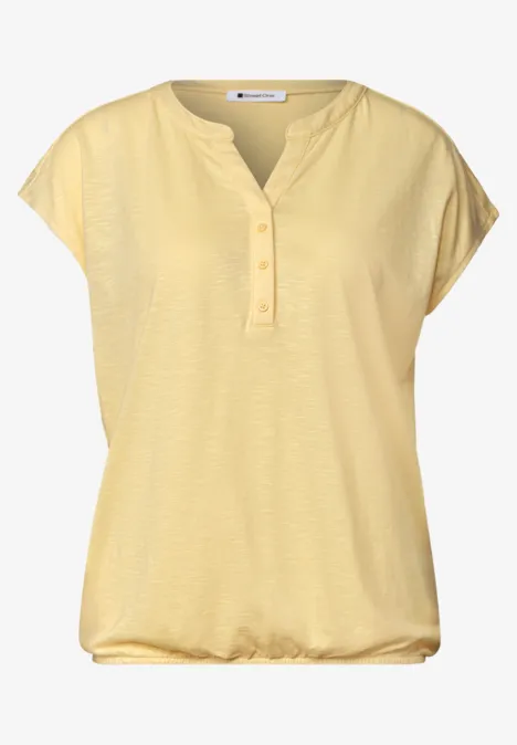 Lichtgeel damesshirt met korte mouwen, V-hals met knoopsluiting en losse zoom
