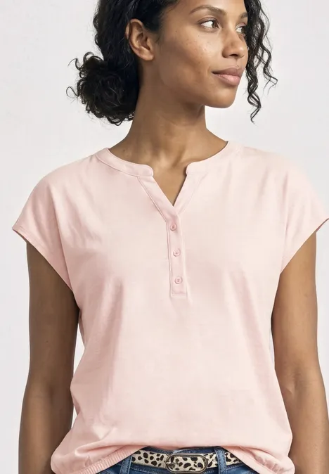 Dropped Shoulder Shirt mit Split Neck minimal rose Person in hellrosa kurzärmligem Oberteil mit Knopfleiste.