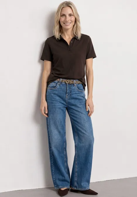 Kurzarm Poloshirt in Rippstruktur espresso brown Stehende Person in schwarzem Poloshirt, weitem Jeans, Leoparden-Gürtel und braunen Schuhen vor weißem Hintergrund.