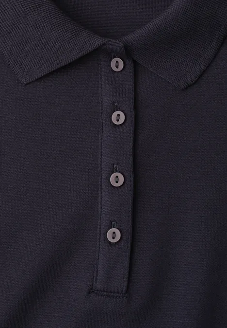 Schwarzes Poloshirt mit Knopfleiste und vier Knöpfen.