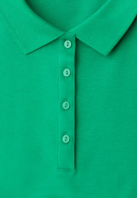 Nahaufnahme eines grünen Poloshirts mit Knopfleiste