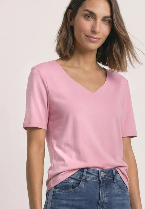 Kurzarm Shirt mit Herzausschnitt vintage blush Frau in rosa Kurzarm-Shirt mit V-Ausschnitt kombiniert mit Jeans.