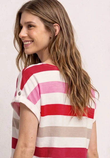 Ansicht von hinten: Ein Mädchen trägt ein T-Shirt mit roten, rosa und weißen Streifen.