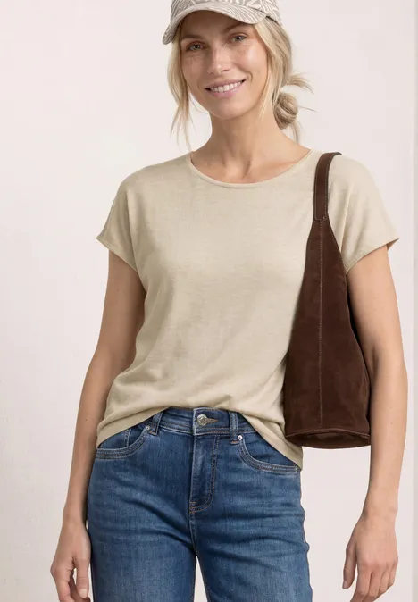 Shirt met korte mouwen en boothals moonstone sand Vrouw draagt beige T-shirt, blauwe jeans en bruine schoudertas tegen lichte achtergrond.