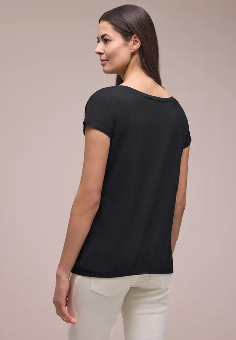 Shirt met ronde hals en rimpels Black Achteraanzicht van persoon in zwart shirt en witte broek voor neutrale achtergrond.