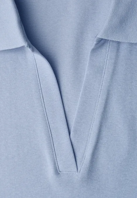 Close-up van een lichtblauw poloshirt met V-hals.