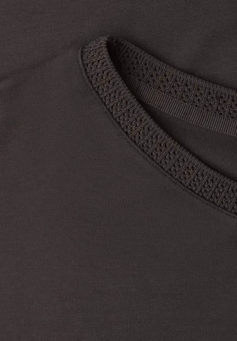 Close-up van een zwart T-shirt met ronde hals en fijne siernaad.