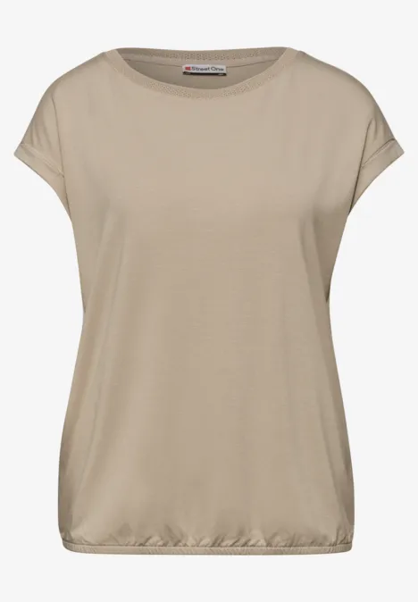 Blouse beige à manches courtes en tissu fluide, encolure bateau et revers légers aux manches.